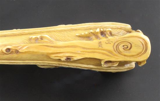 A Japanese ivory okimono of figures enjoying festivities on a boat, Meiji period, 12.3cm, wood stand
